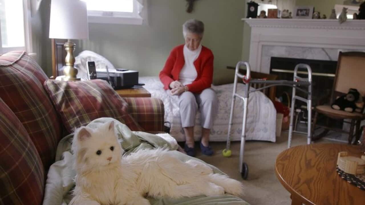 Ninety-three year-old Mary Derr sits near her robot cat.