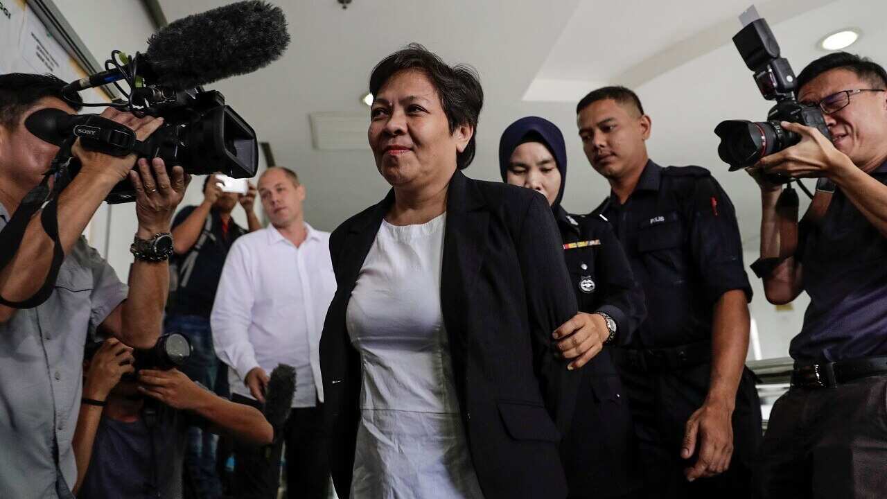 Australian Maria Elvira Pinto Exposto escorted by Royal Malaysian Police officers.