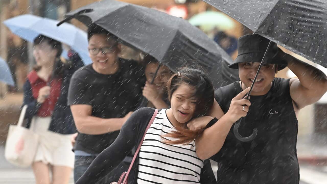 People use umbrellas to shelter from the rain in Keelung city as Typhoon Mitag approached the northeast coast of Taiwan.