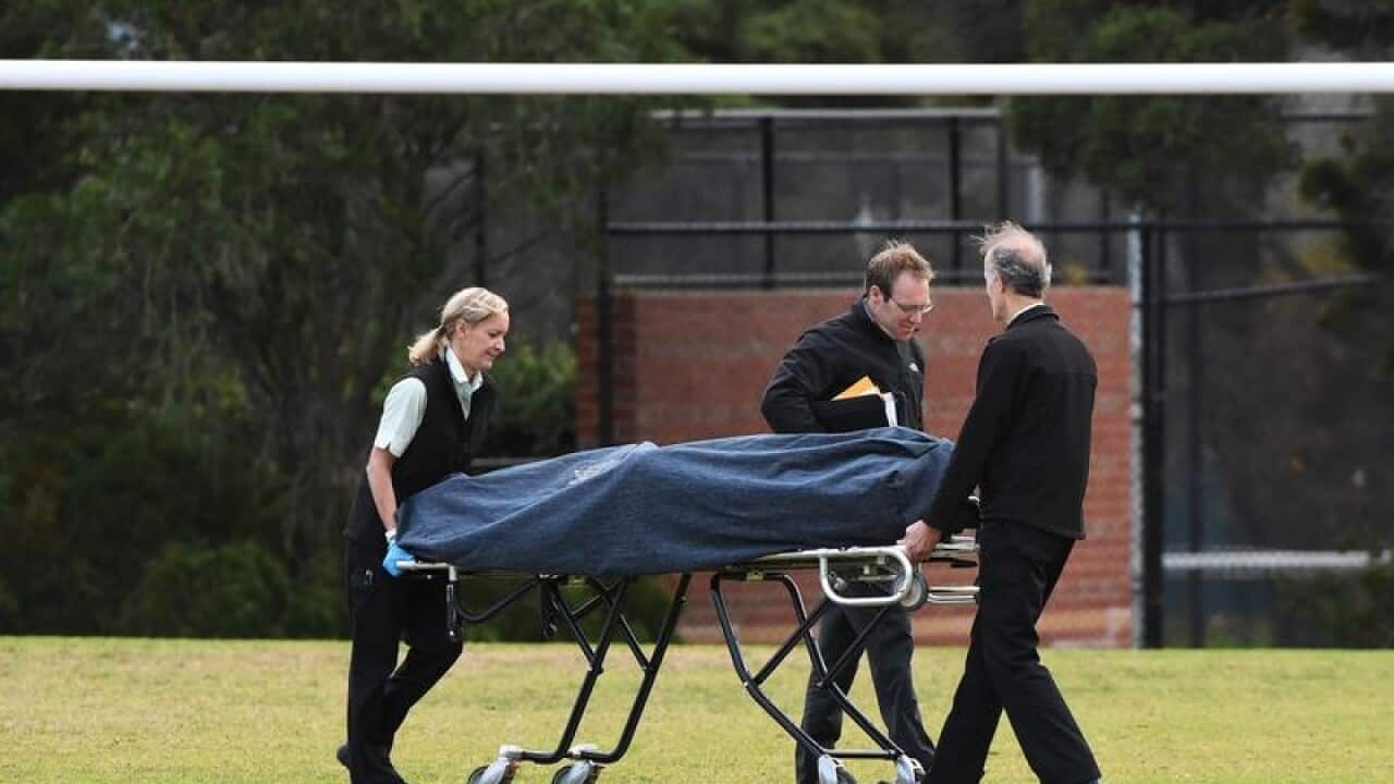 Forensic officers remove a bosy from a crime scene in Melbourne