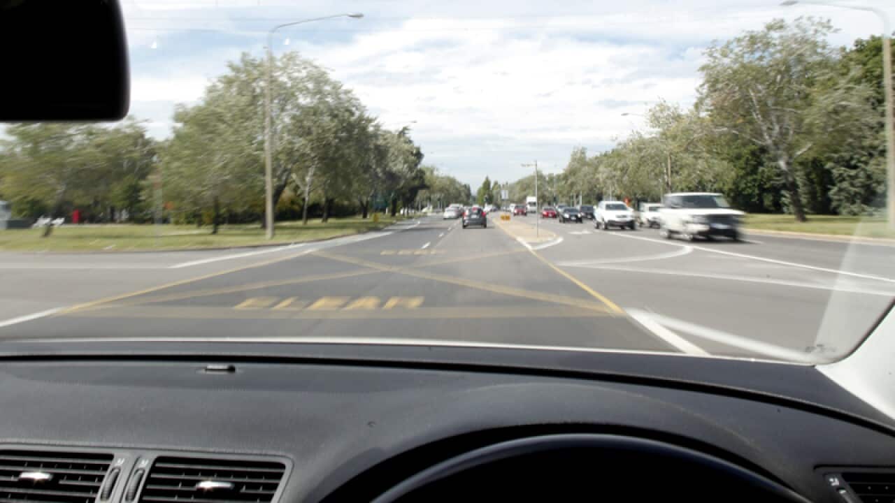 Street scenes are seen out of a driving car