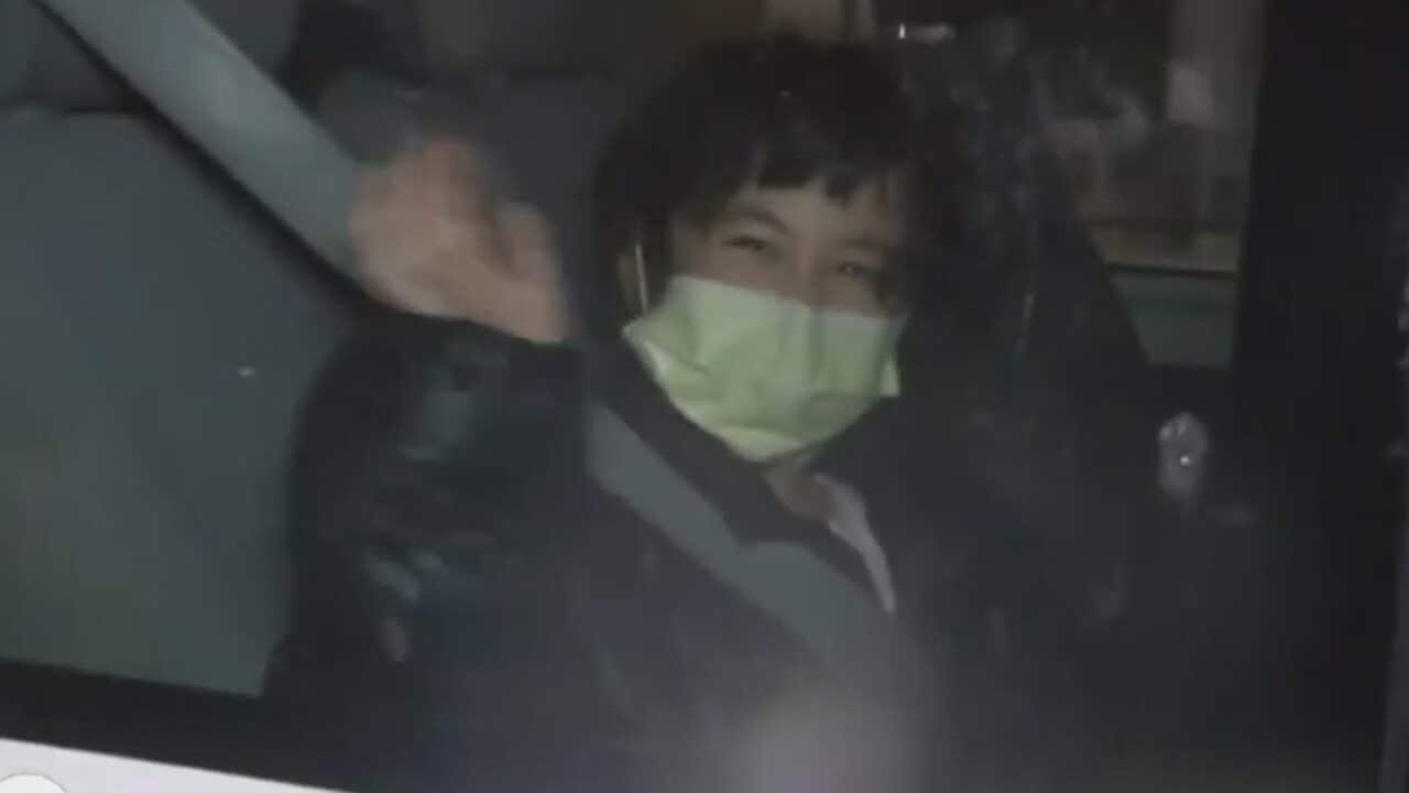 A woman seen smiling and waving after having been evacuated to Christmas Island from the coronavirus epicentre of Wuhan in China.