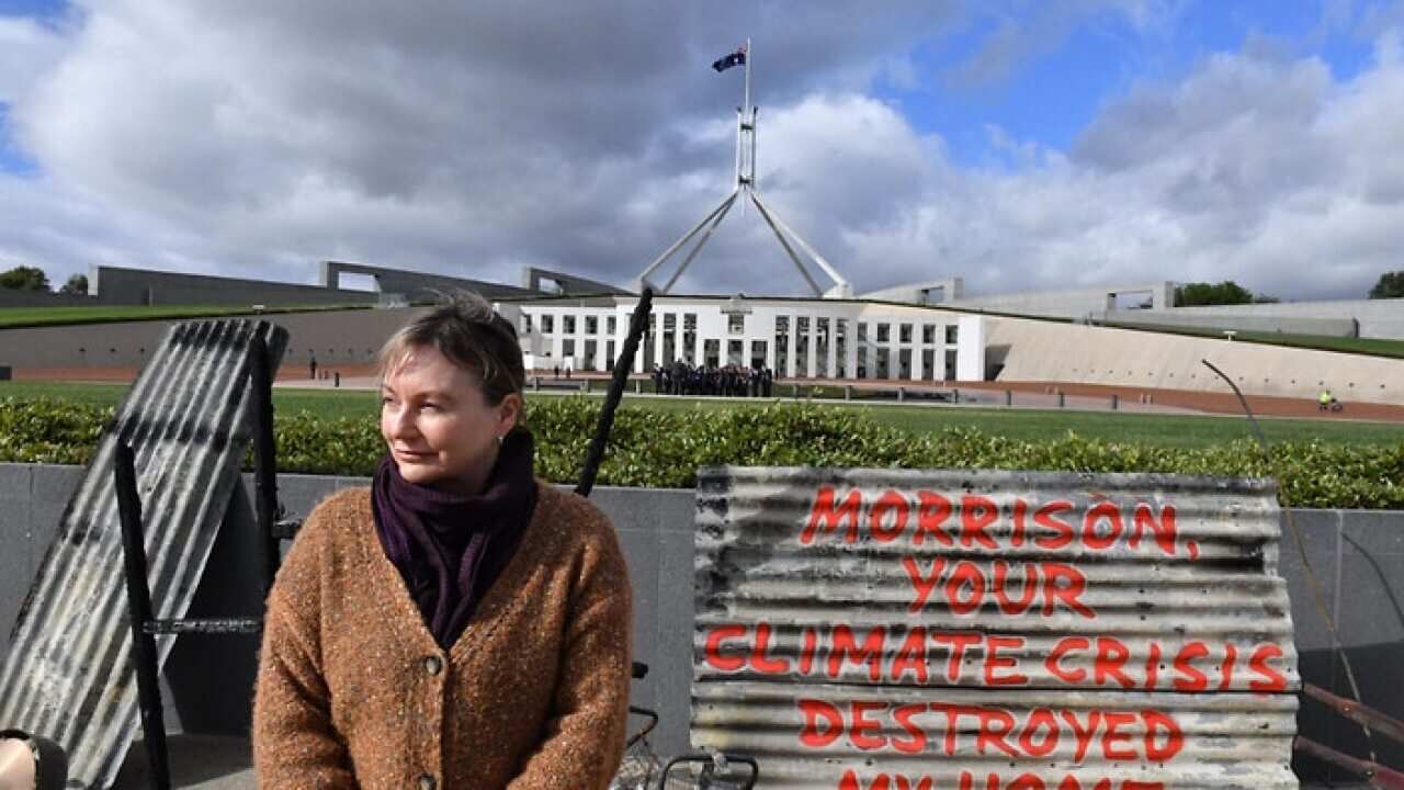 Melinda Plesman stands with the remains of her burnt-out house, outside Parliament House in Canberra, Monday, 2 December 2019.