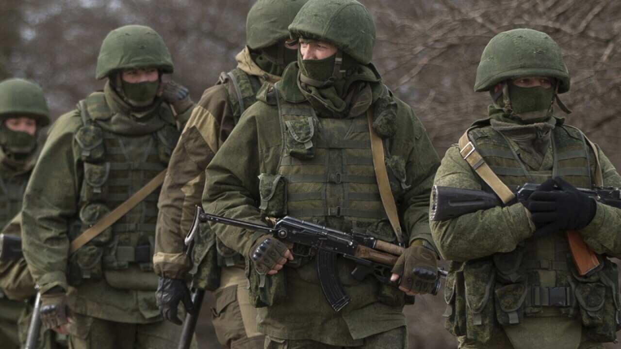 Pro-Russian soldiers march near a Ukrainian army base