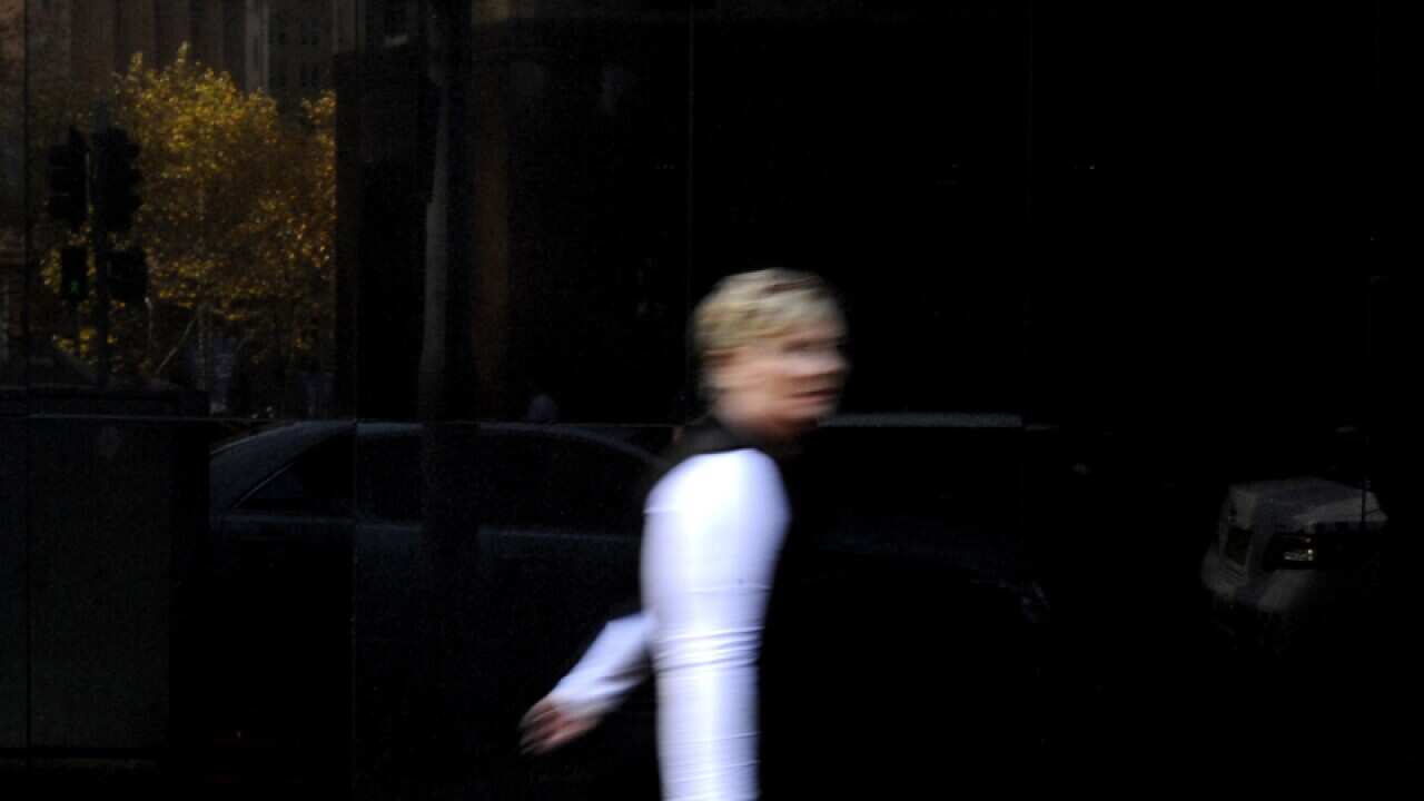 A woman walks past Reserve bank of Australia signage