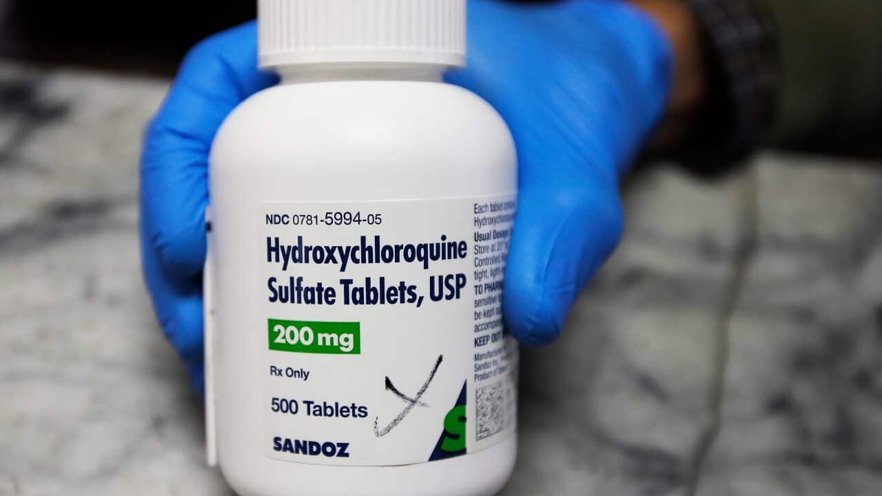 A pharmacist shows a bottle of the drug hydroxychloroquine.