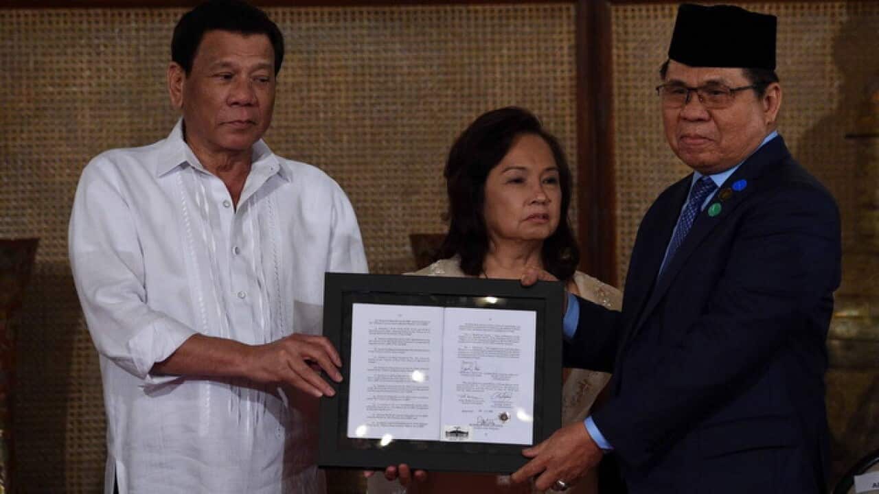 presents the signed document on the Organic Law for Bangsamoro Autonomous Region of Muslim Mindanao