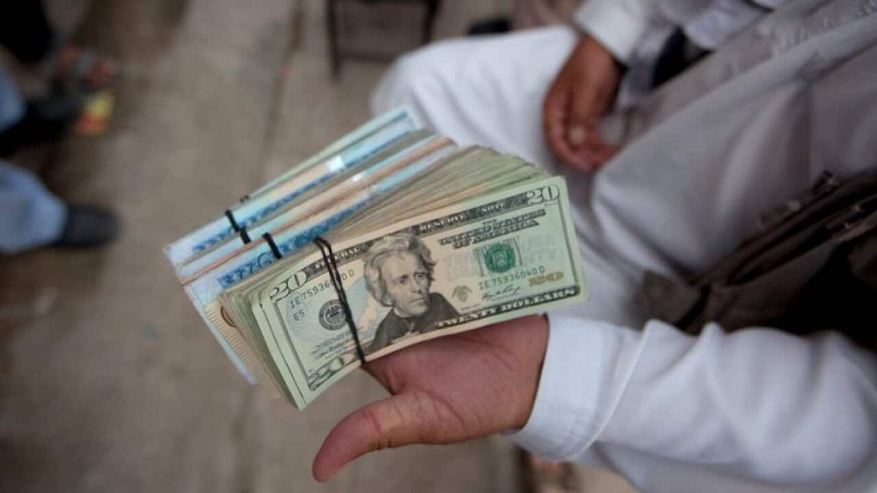 Money changer at the bazaar displays his currency wares
