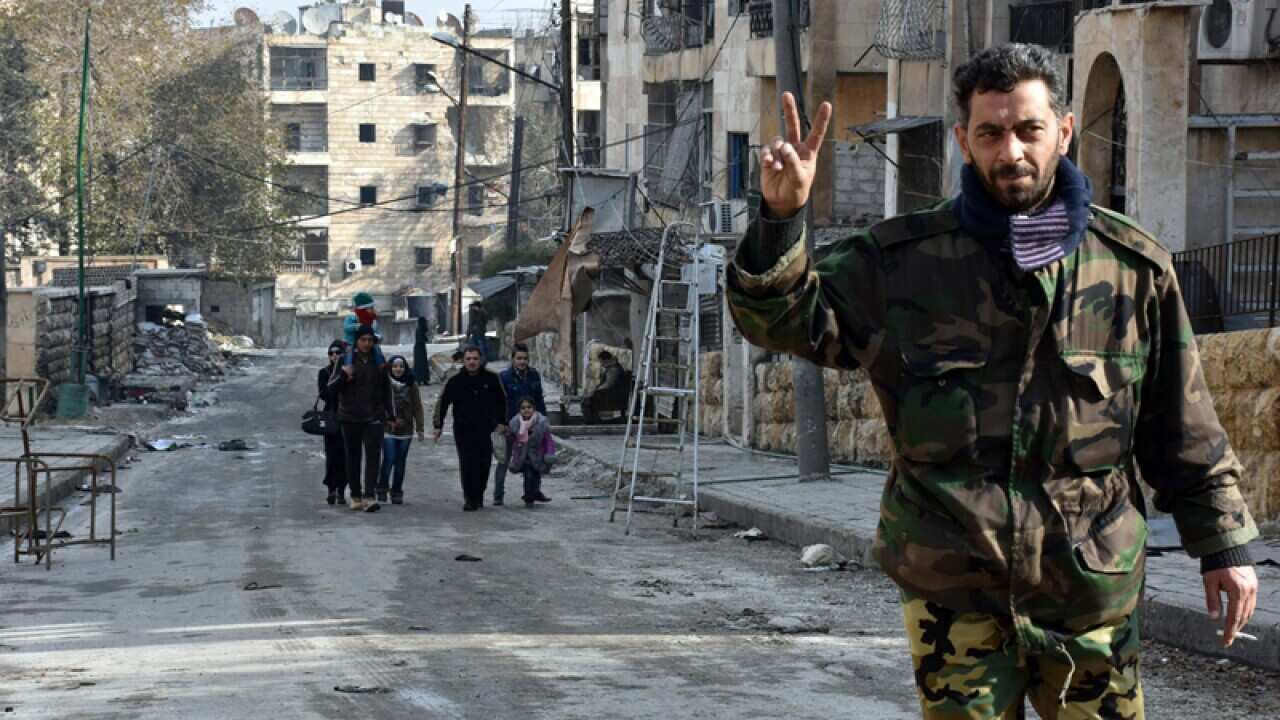 A soldier flashes the victory sign in a district of Aleppo