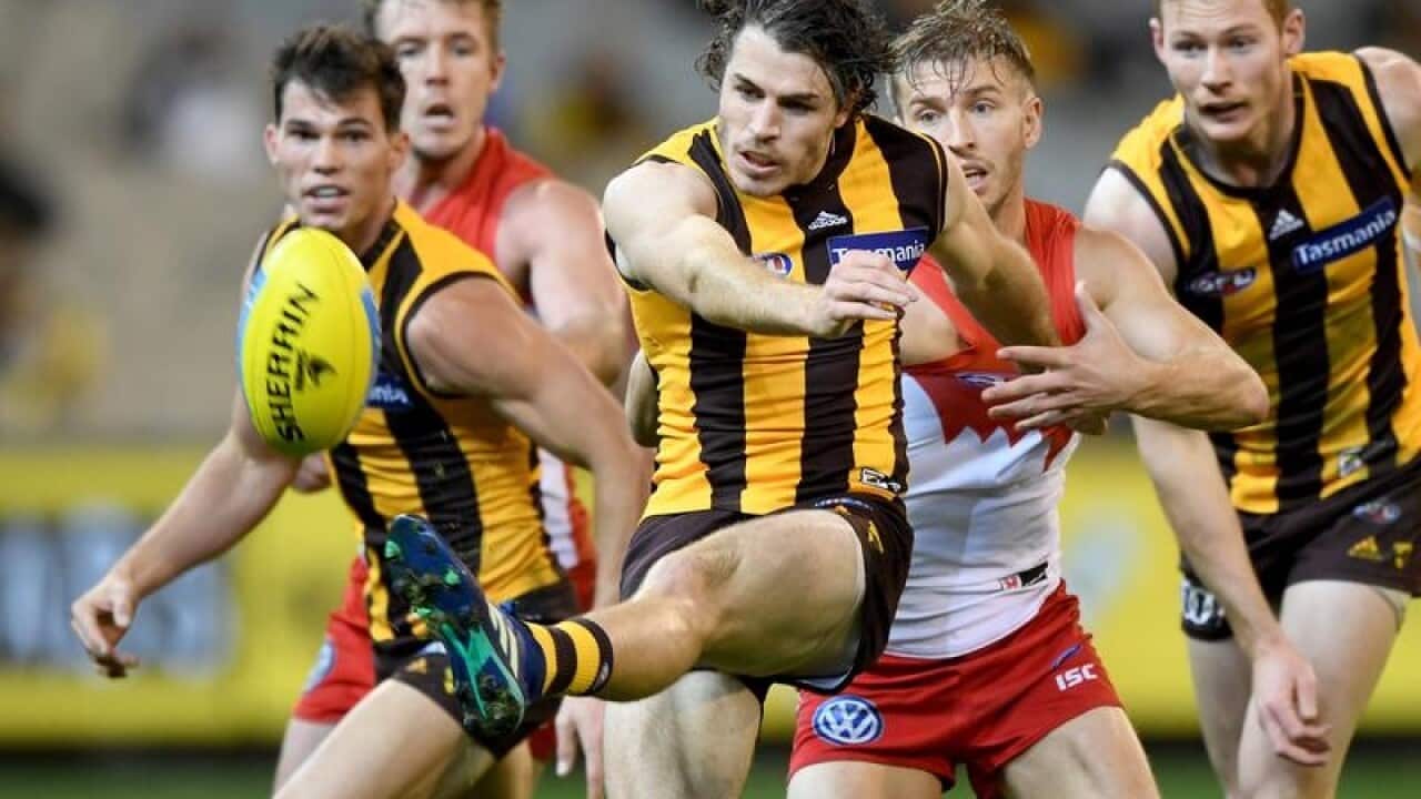 Isaac Smith of the Hawks clears the ball.