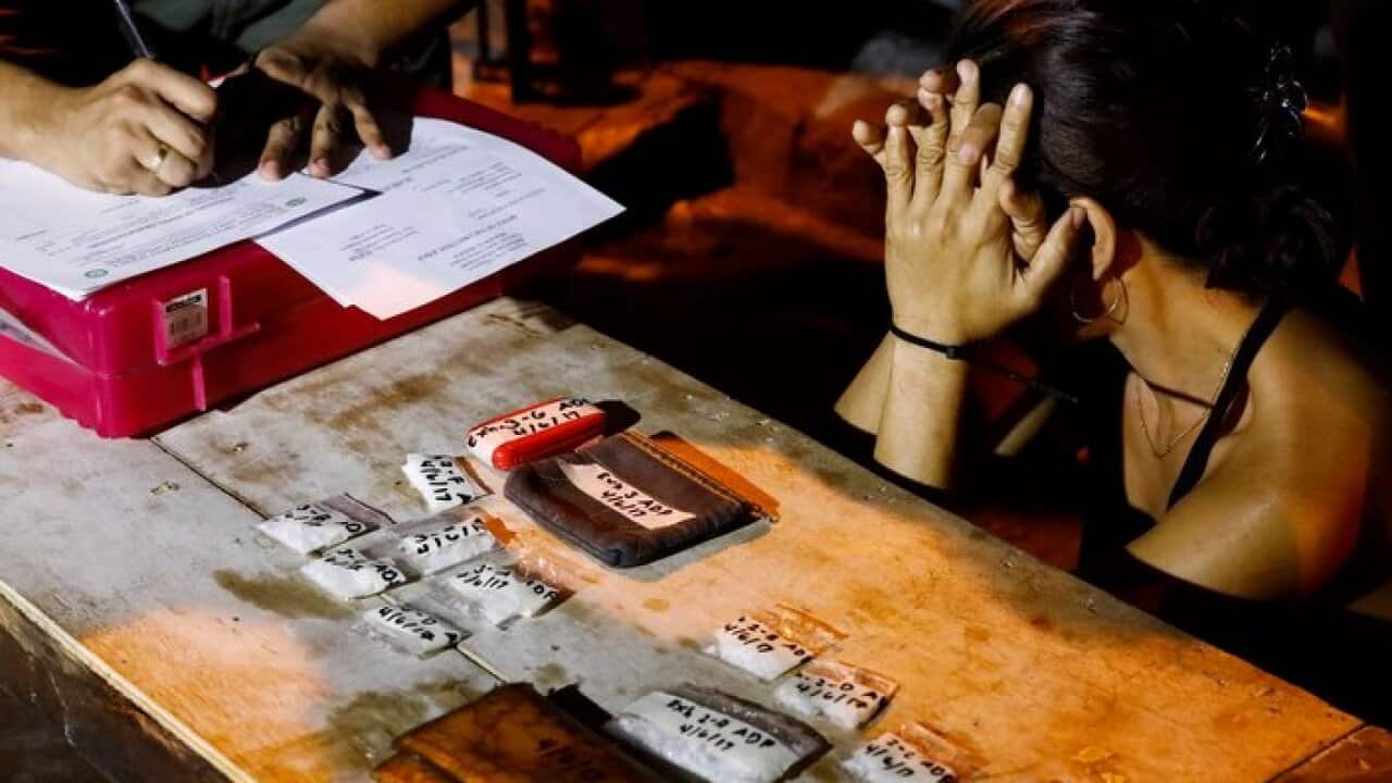 A police officer questions a drug suspect