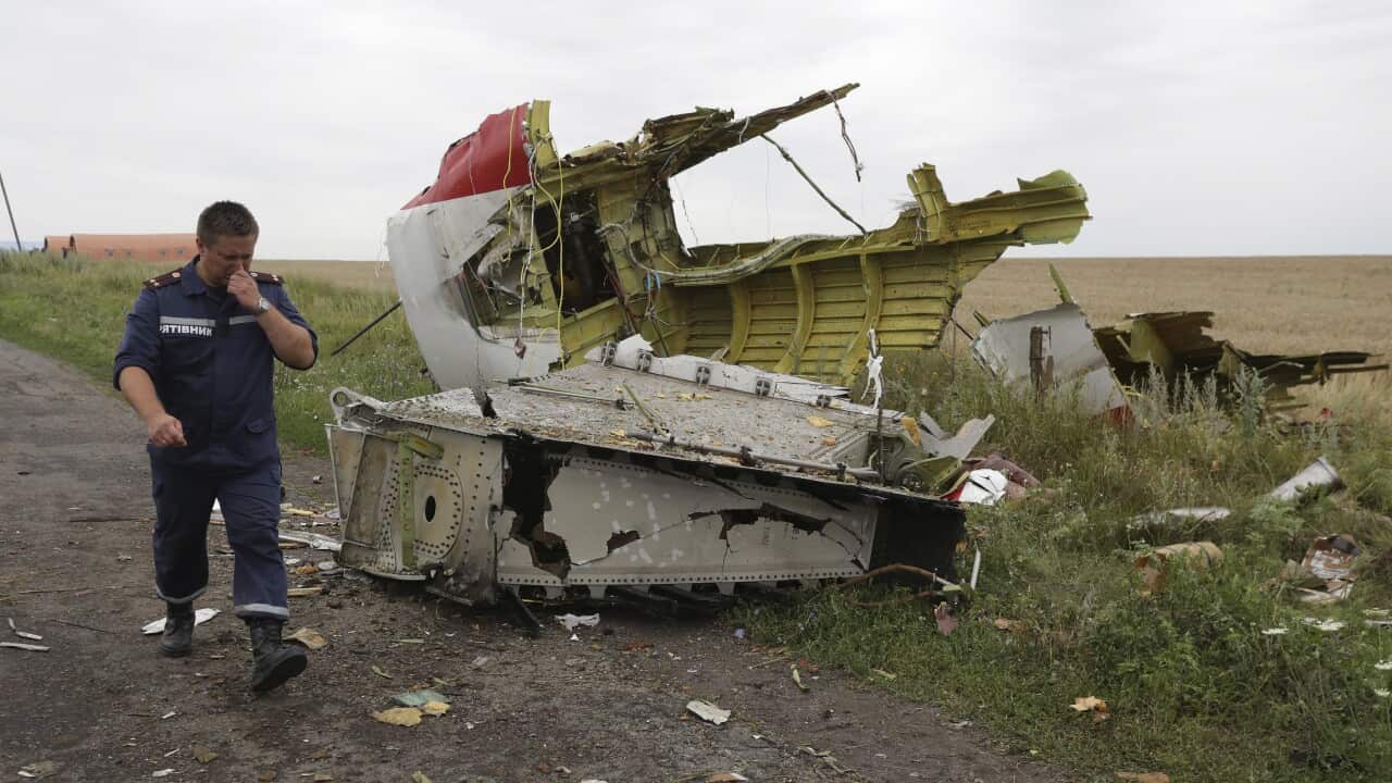 A Ukrainian rescue worker passes wreckage of the Boeing 777 plane of Malaysia Arilines flight MH17.
