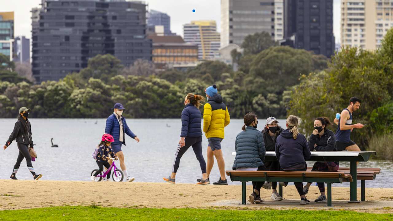 People are seen exercising and socialising at Albert Park Lake in Melbourne, 19 September 2021.