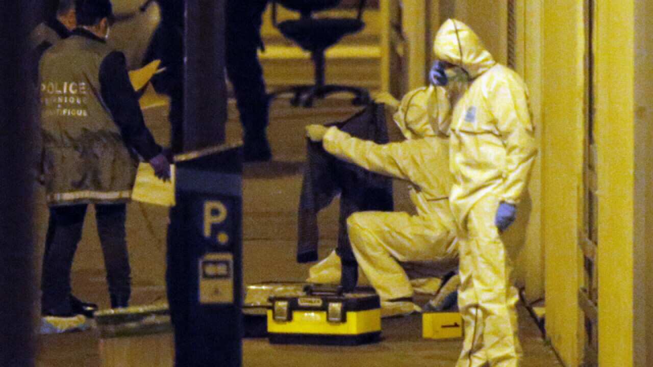 Forensic experts examine evidence outside the Charlie Hebdo office
