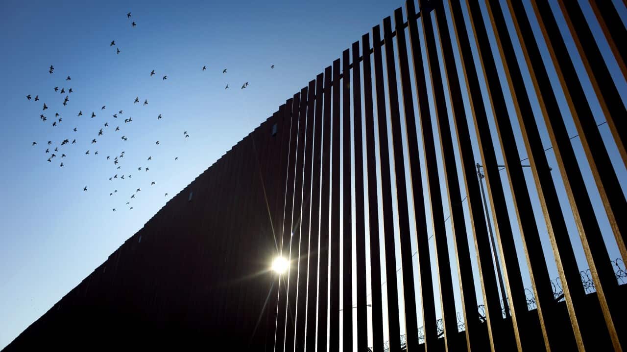 Birds fly over a section of the recently renovated US-Mexico border wall, in Calexico, California, USA.