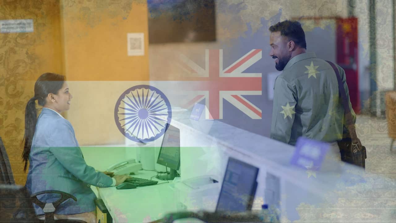 A man of Indian origin in a passport services office talking to a woman behind the counter, with Indian and Australian flags in the background, merged with the image