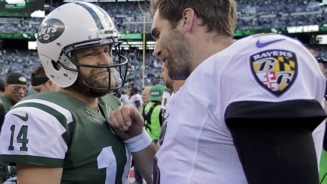 Jets' Ryan Fitzpatrick (14) talks with Ravens' Joe Flacco