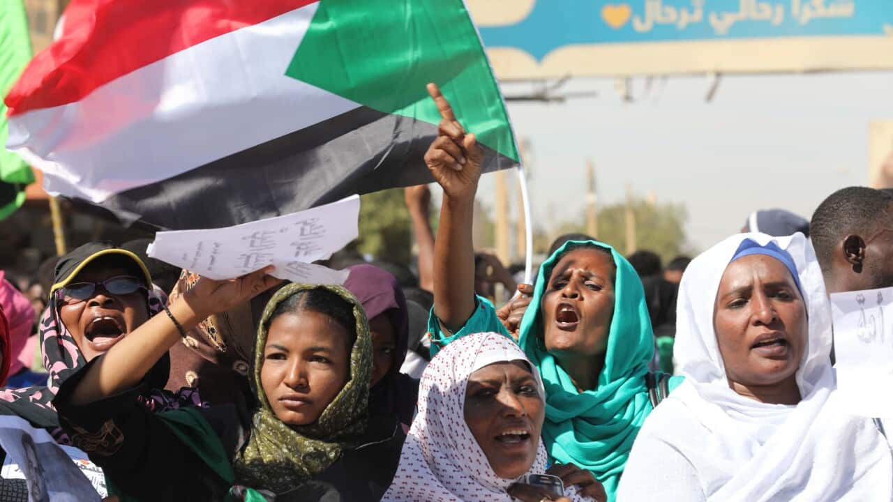Sudanese people react to the sentence as they gather in front of a court in Omdurman, near the capital Khartoum.