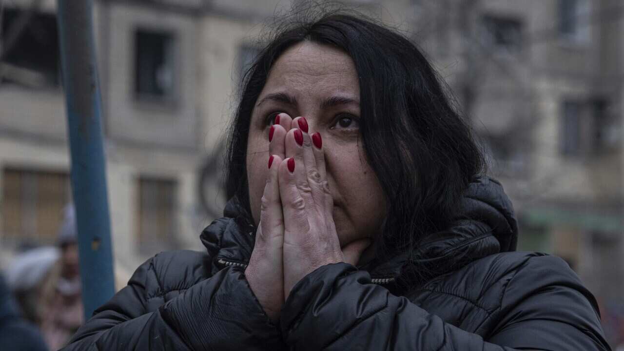 A woman reacts looking at the damage caused to an apartment building that was destroyed in a Russian rocket attack at a residential neighbourhood in the southeastern city of Dnipro, Ukraine, Sunday, Jan. 15, 2023.
