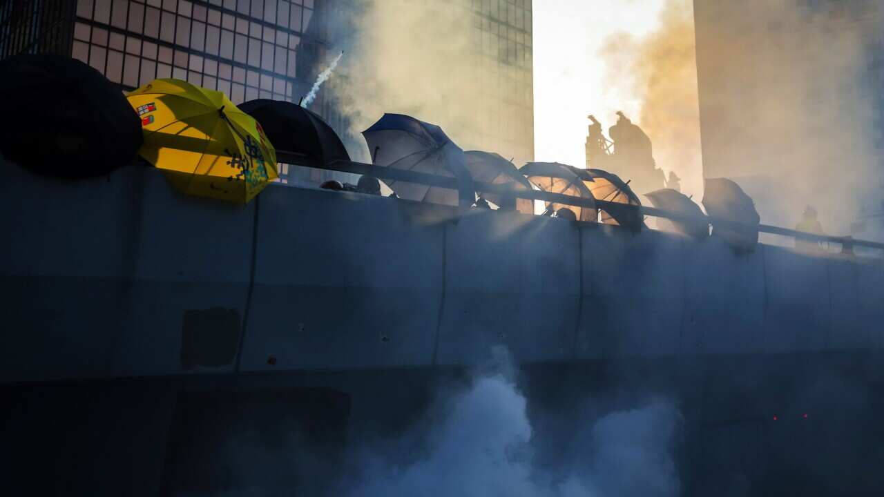 Protesters use umbrellas to shield themselves from tear gas canisters in Hong Kong