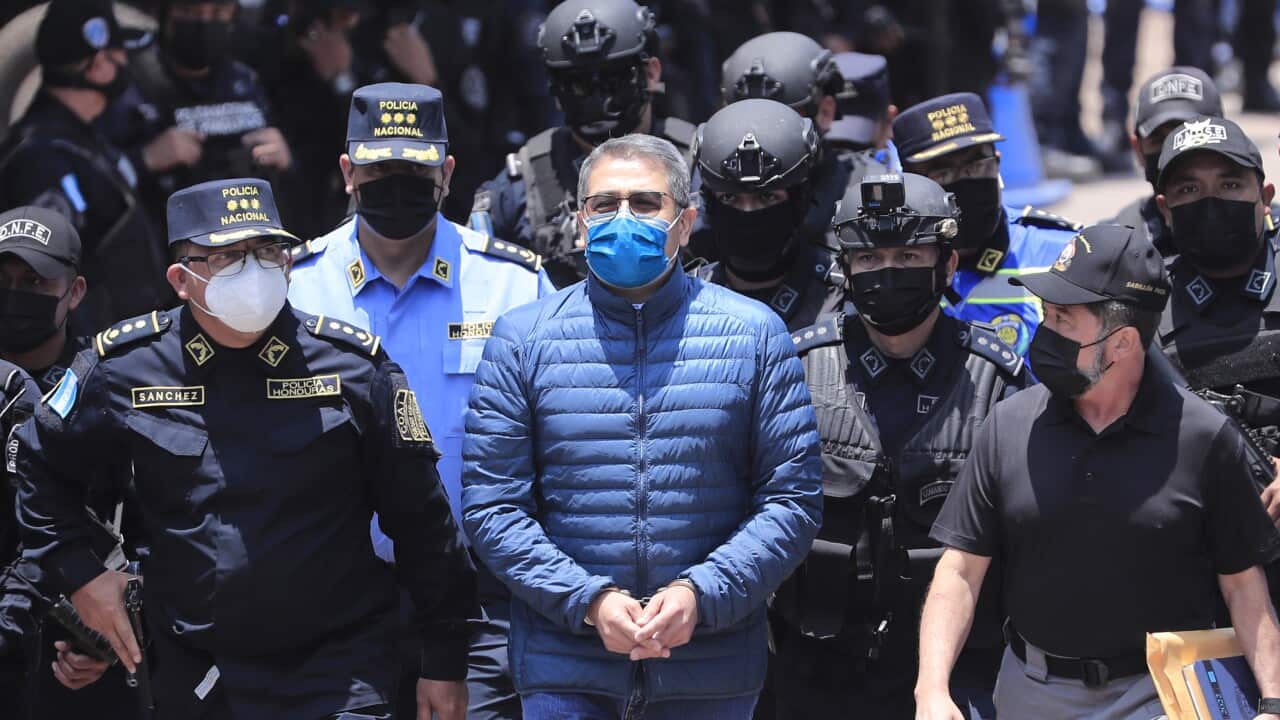 Former Honduran President Juan Orlando Hernandez walks surrounded by police agents during his extradition process at the headquarters of the National Special Forces Directorate, in Tegucigalpa, Honduras, 21 April 2022.