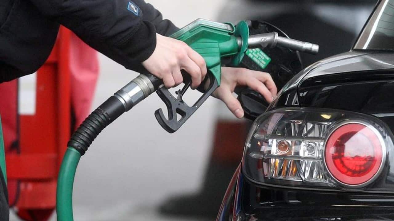 A man using at petrol pump filling his car.