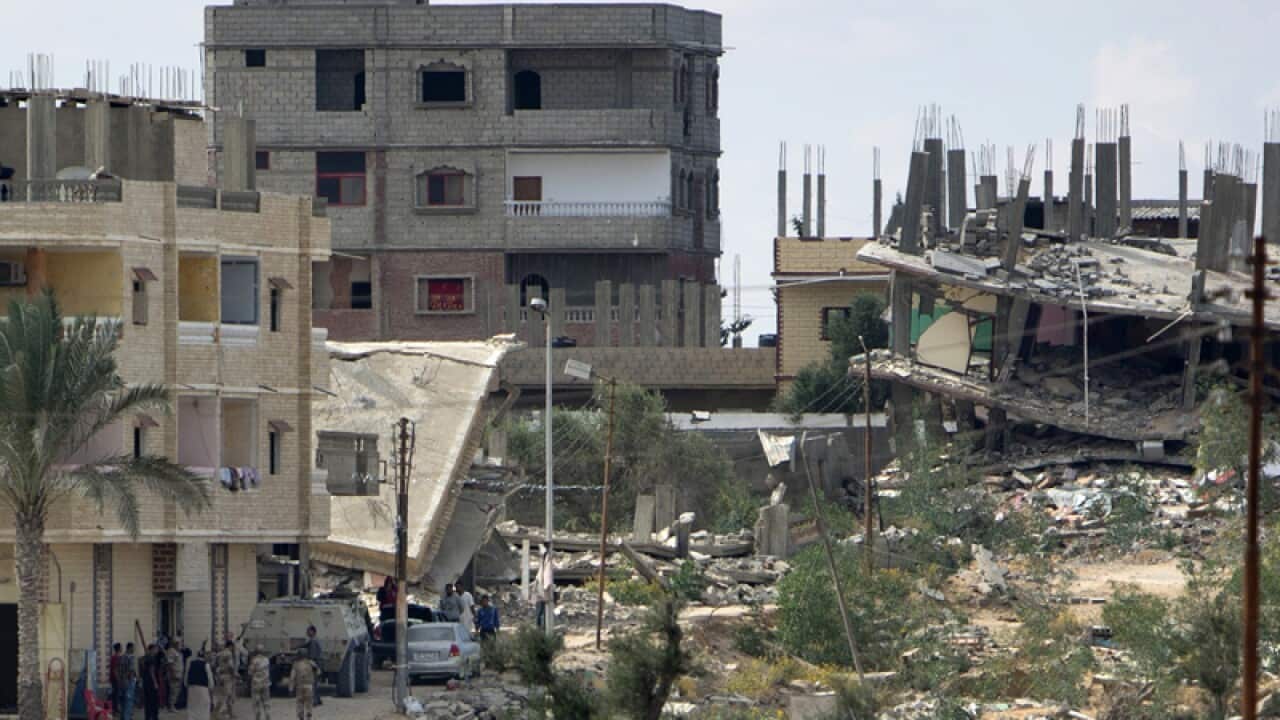 Egyptian army troops walk amid debris