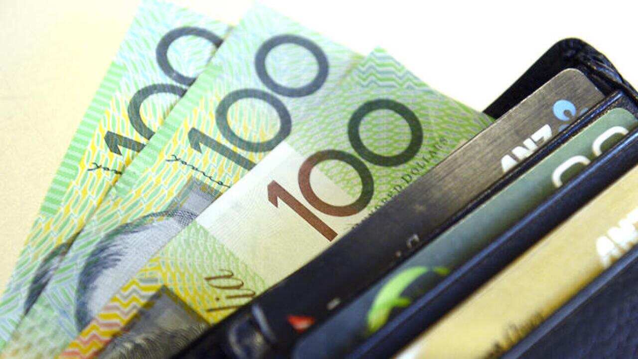 $100 Australian dollar notes pop out of a wallet with credit cards, pictured in Brisbane, Tuesday, Aug. 20, 2013. (AAP Image/Dan Peled) NO ARCHIVING