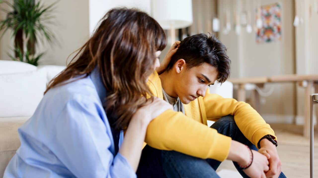 Worried son talking about school bullying with his mother