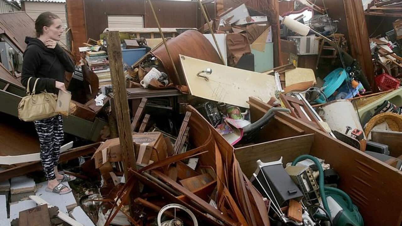 Haley Nelson inspects damages to her family property.
