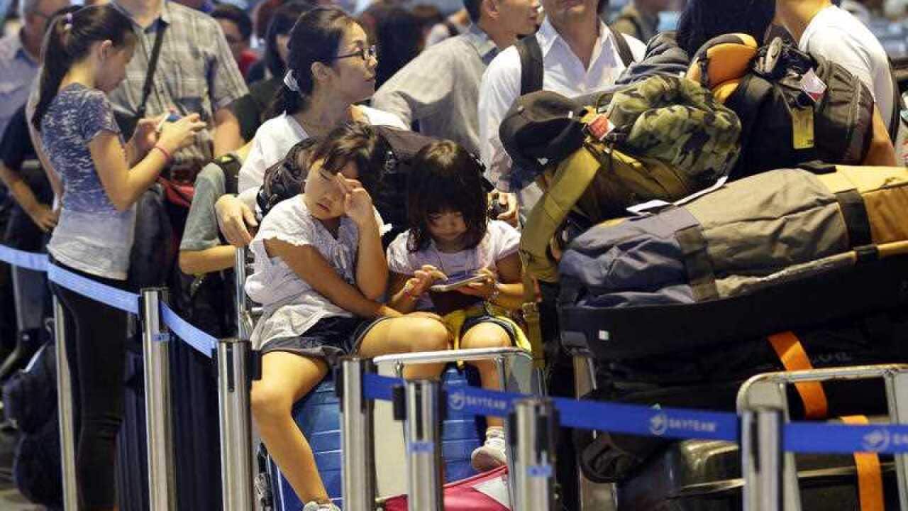 Passengers line up at check-in counter for Delta Air Lines at Narita international airport, Tokyo, Tuesday, Aug. 9, 2016.