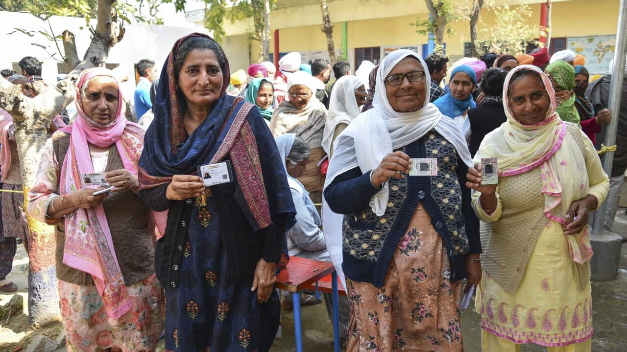 Village women display their voter identity cards as they arrive to cast their votes for the Punjab State Assembly elections in village Jagdev Kalan, outskirts of Amritsar, India, Sunday, Feb. 20, 2022. (AP Photo/Prabhjot Gill)