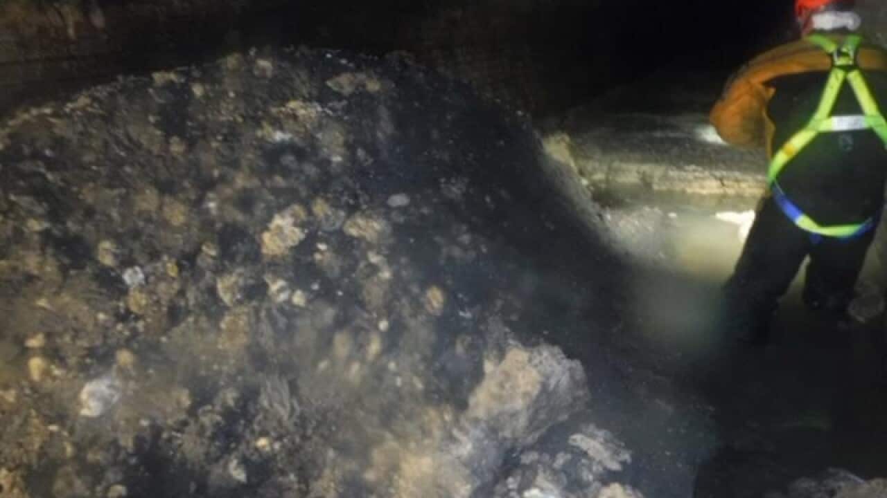 An engineer inspects the fatberg blocking the sewer in Sidmouth