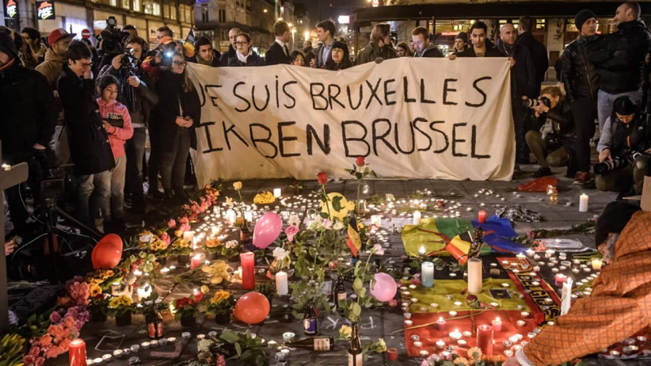 People gather in Bourse square to pay tribute following deadly blasts