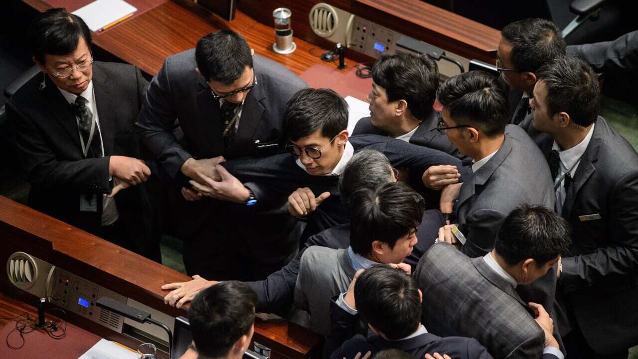Newly elected lawmaker Baggio Leung (C) is restrained by security after attempting to read out his Legislative Council oath at Legco in Hong Kong on November 2, 2016.