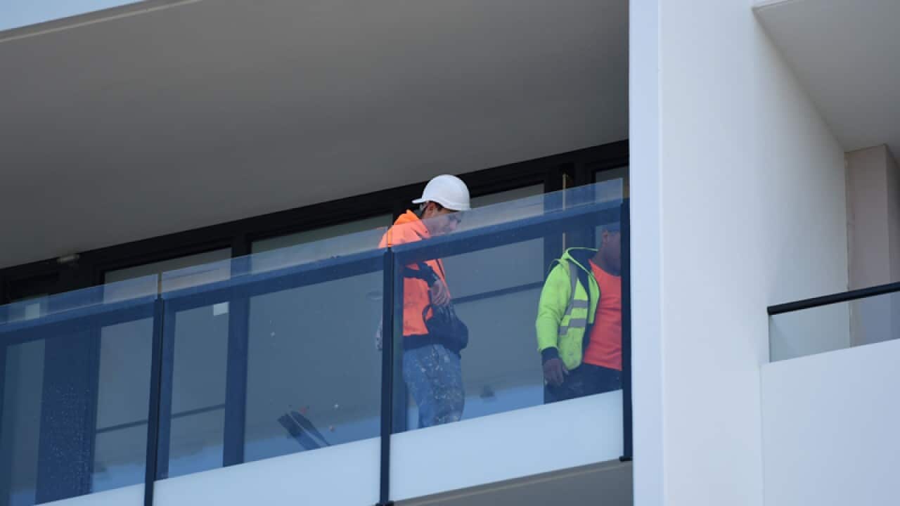 Builders work on new apartments in Melbourne