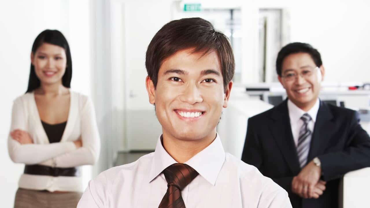 Businessman Standing in Front of Coworkers
