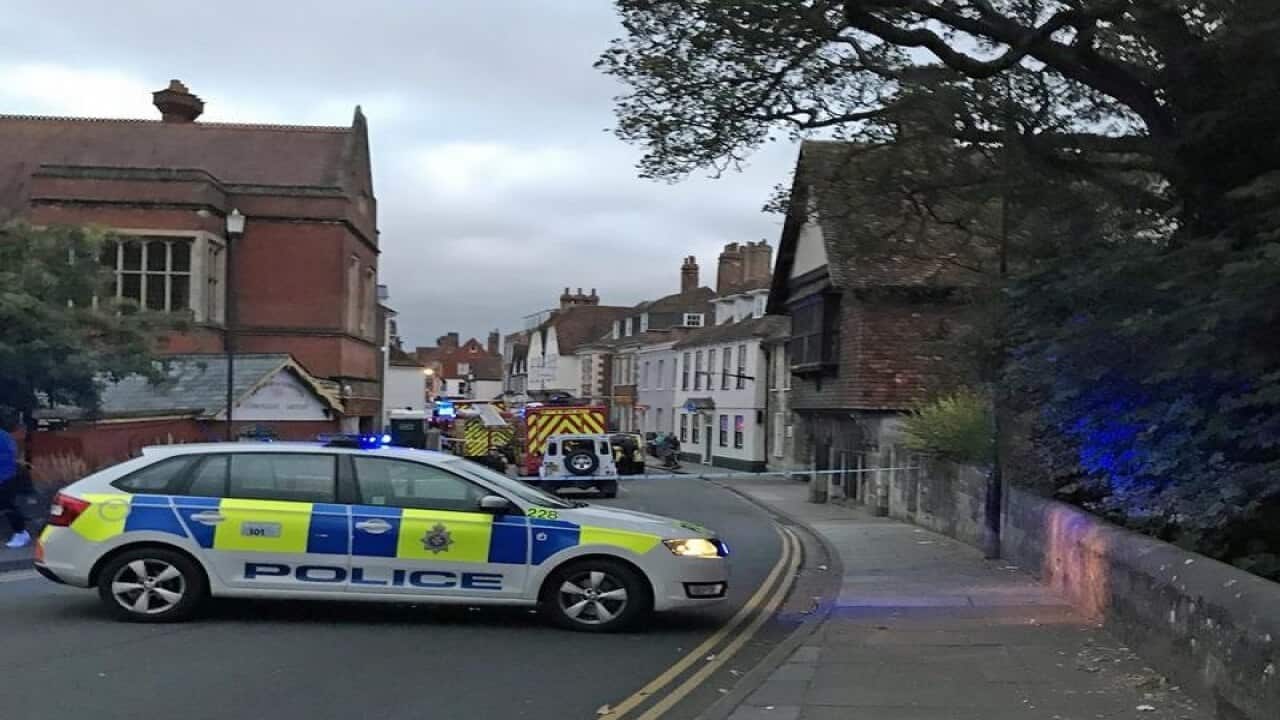 A police car blocks the road outside the restaurant.