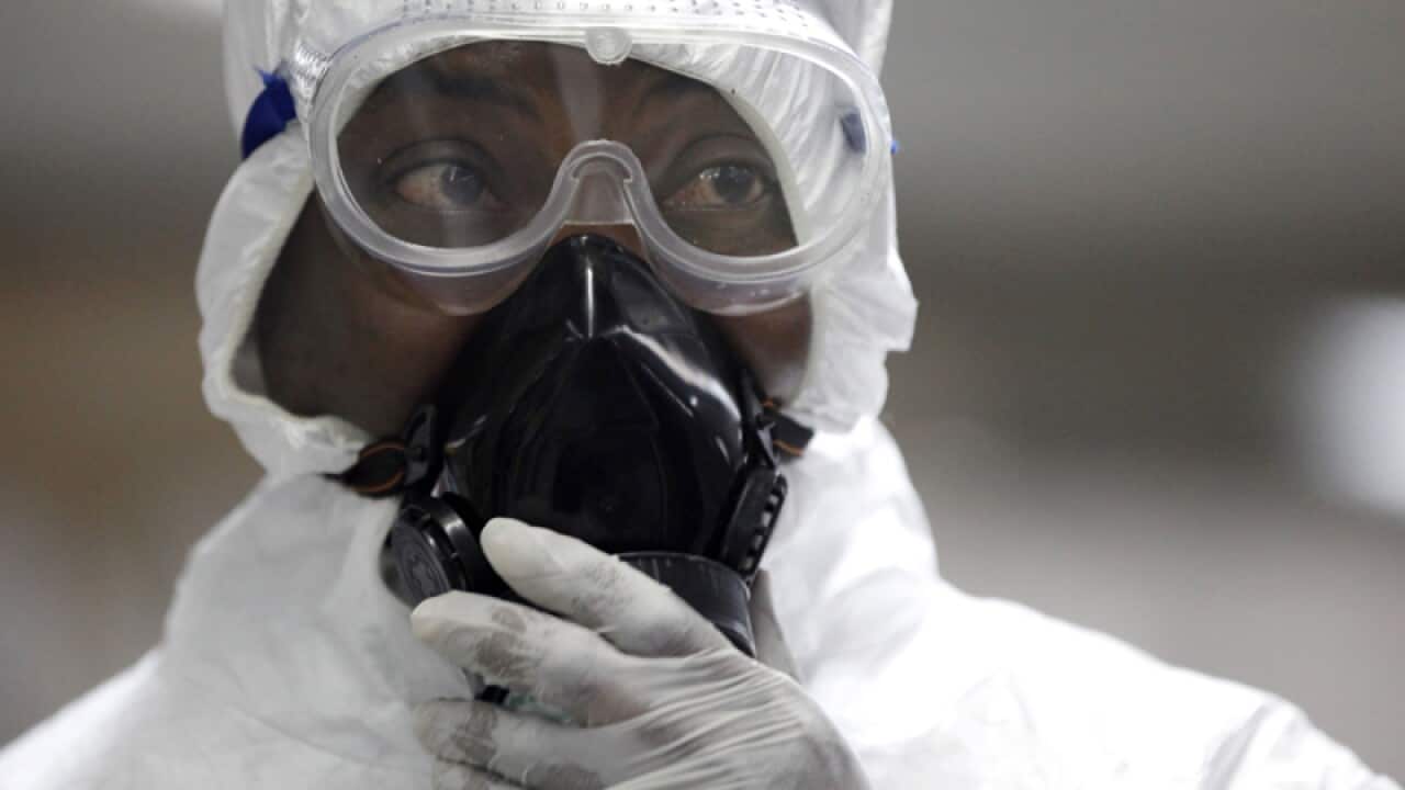 a Nigerian health official screens passengers for the Ebola virus