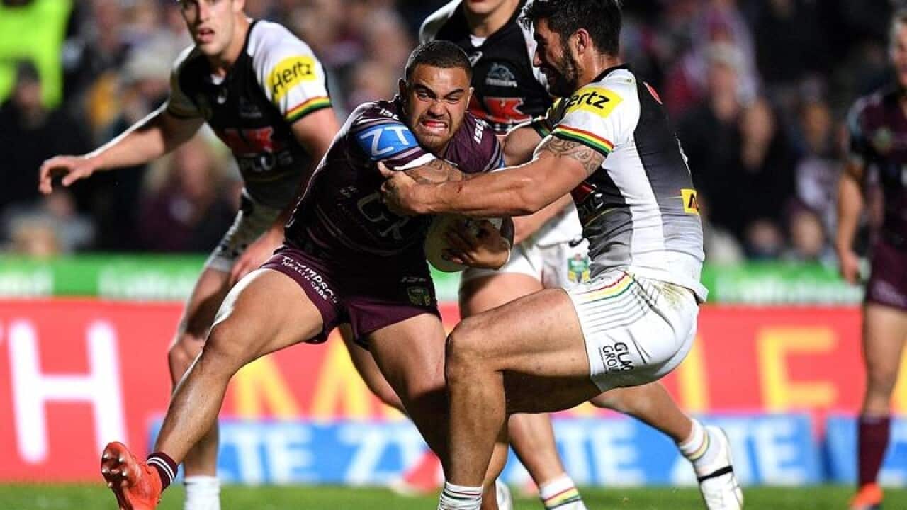 Dylan Walker of the Sea Eagles is tackled by James Tamou.