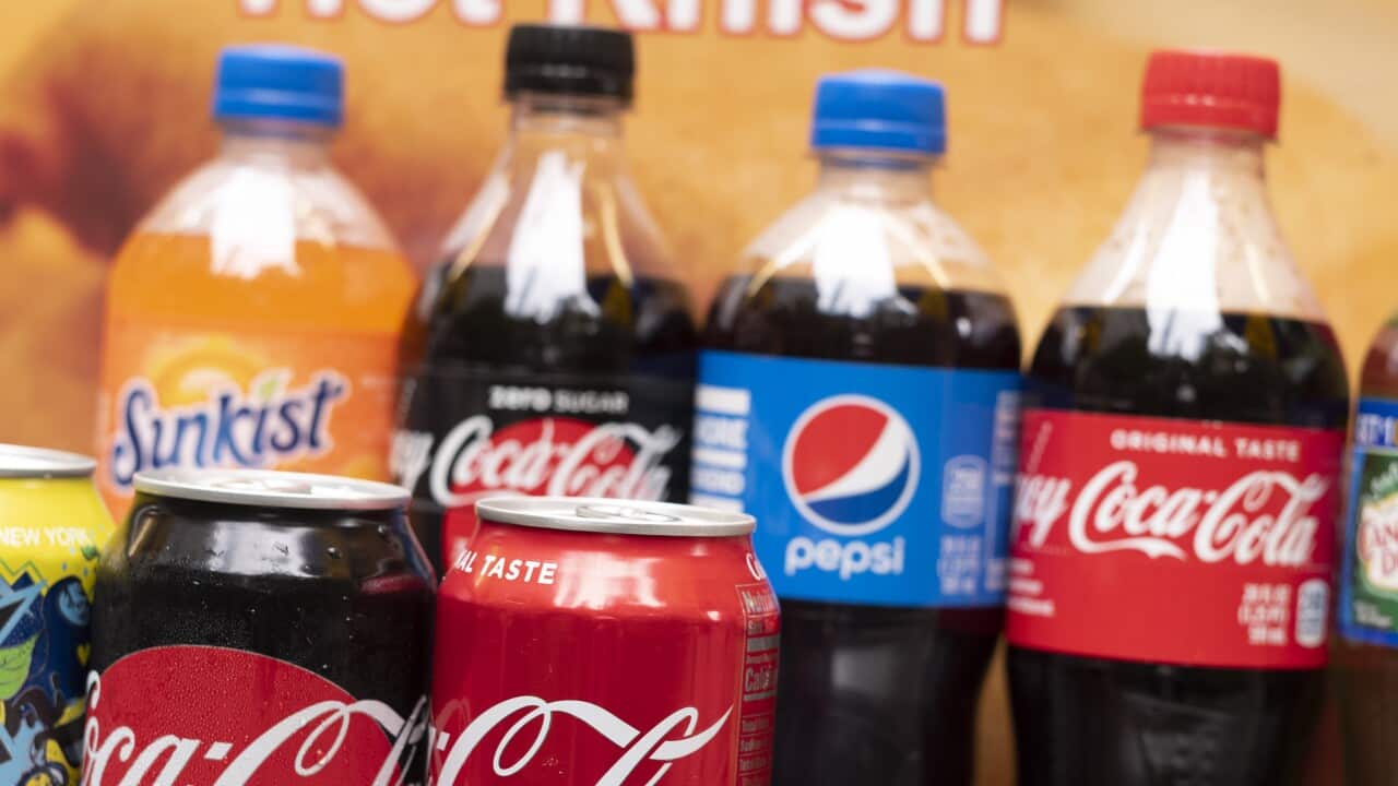Coke and Pepsi soft drinks are displayed on a food cart.