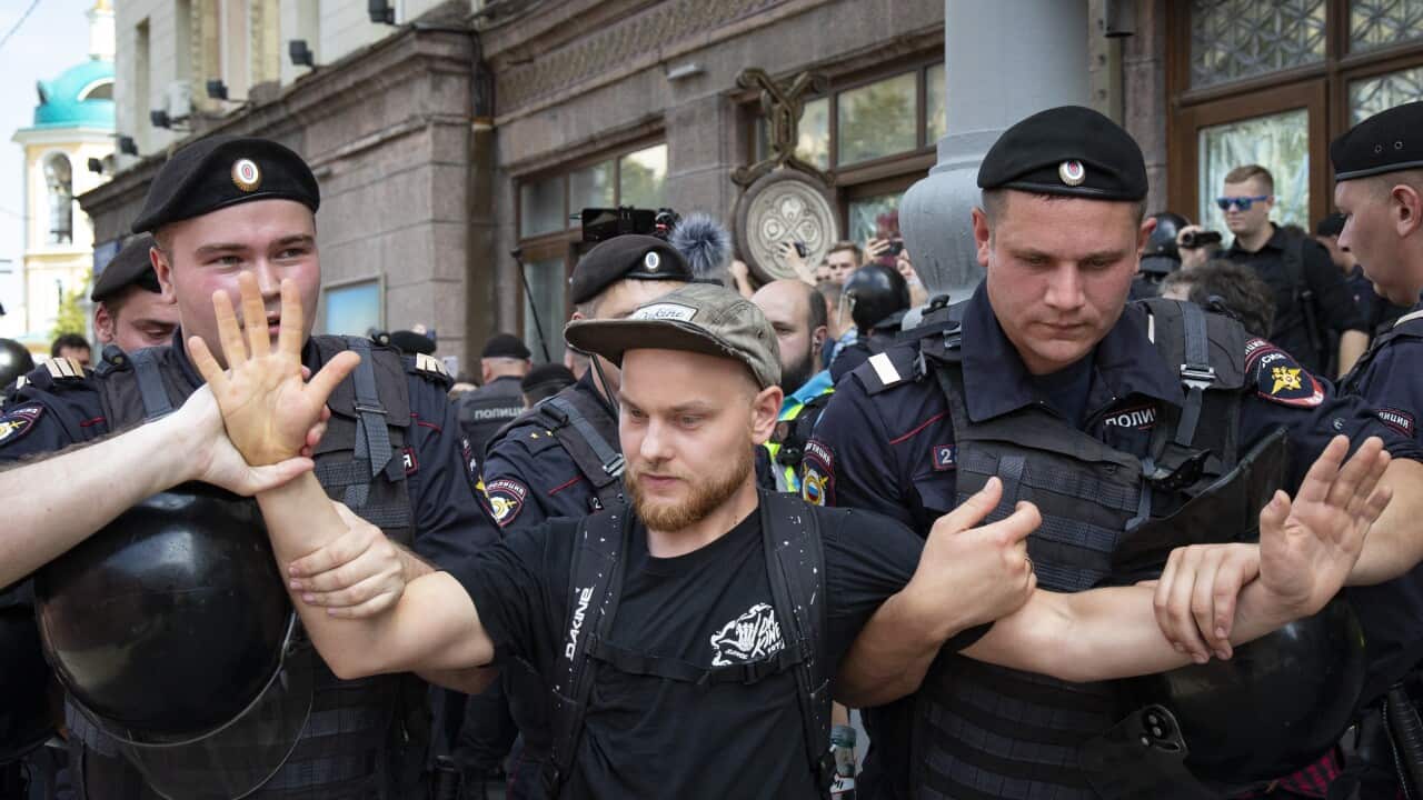 Police officers detain a protester during an unsanctioned rally in the center of Moscow.