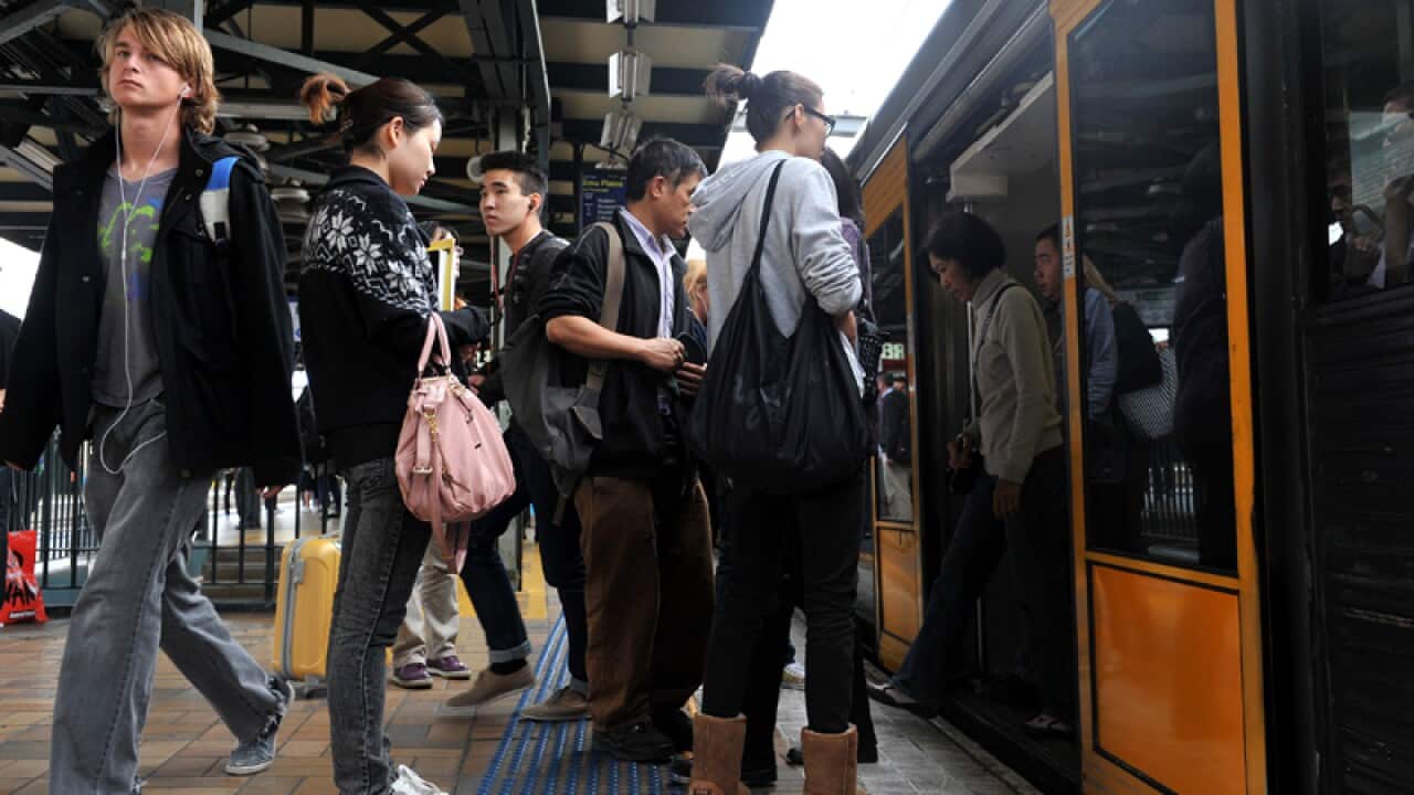 Commuters depart and board a train at a station in Sydney