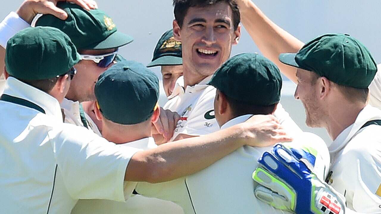 Australian bowler Mitchell Starc (C) celebrates a dismissing