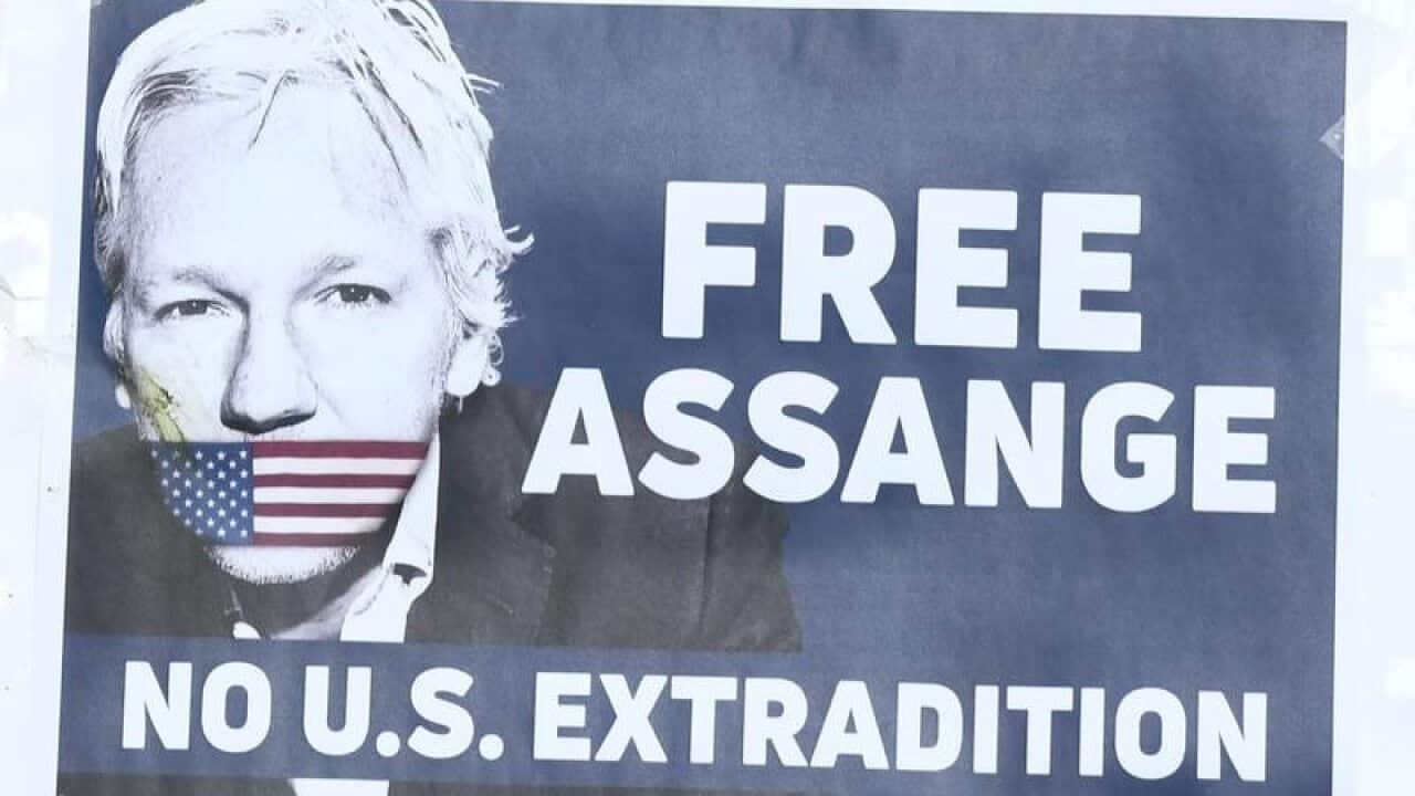 Supporters of Julian Assange holding up placards at a rally.