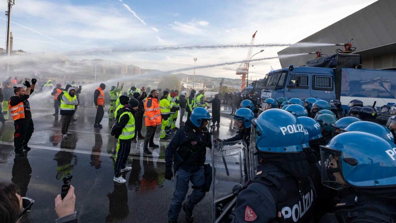 Italian law enforcement officers start an operation to clear protestors against the Green Pass from a section of the port of Trieste, northern Italy.
