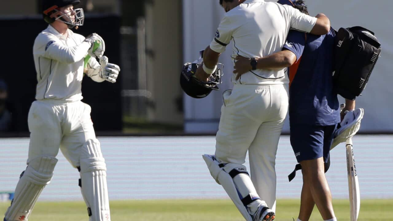 Ross Taylor is assisted from the field after injuring his leg