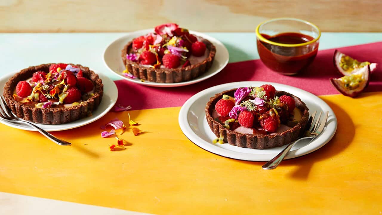 Raw raspberry, ginger and chocolate tarts with passionfruit and dark chocolate sauce