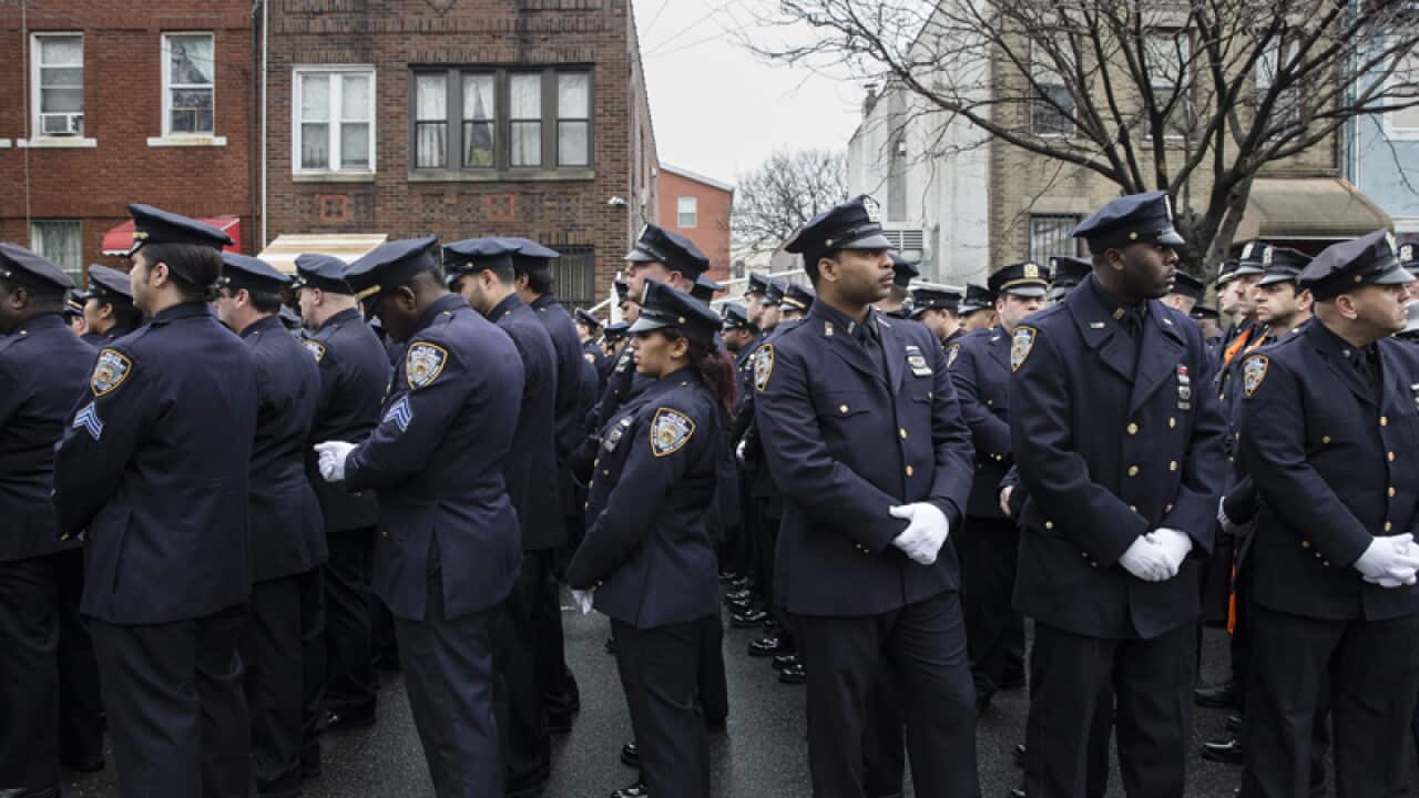 Police officers turn their back during the funeral of Wenjian Liu