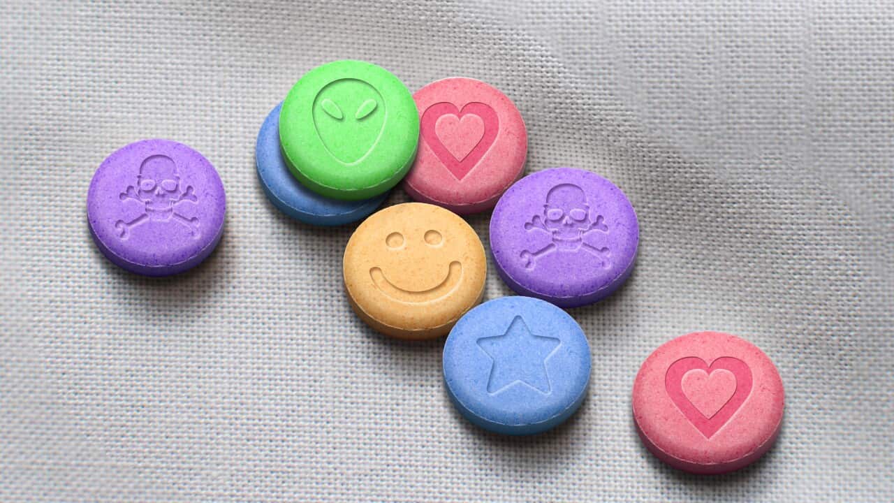 MDMA or ecstasty pills on a white fabric background